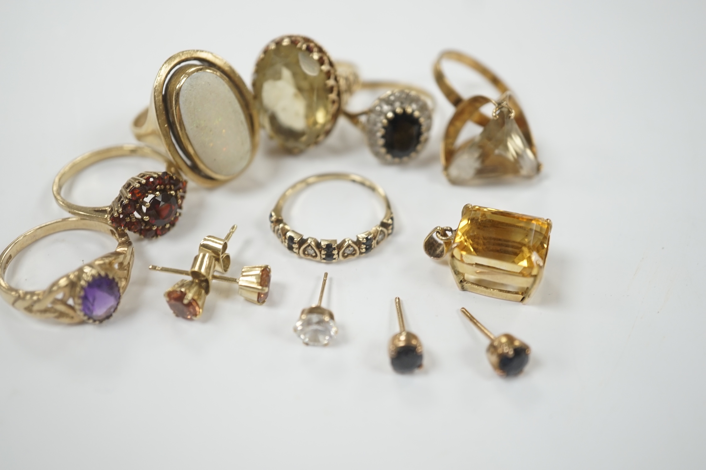Seven assorted modern 9ct and gem set rings, including garnet cluster, white opal and amethyst, gross weight 26.2 grams, together with a pendant and assorted ear studs.